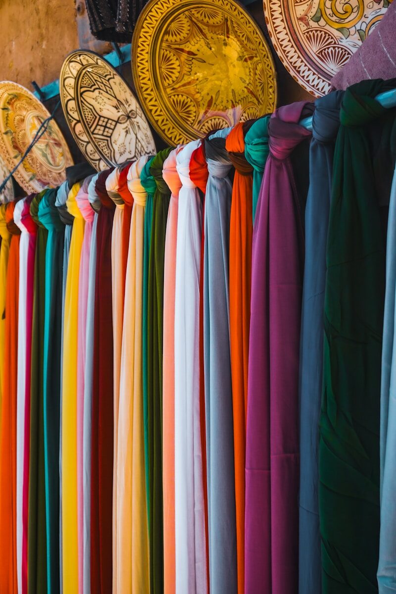 A rack of different colored shirts hanging on a wall